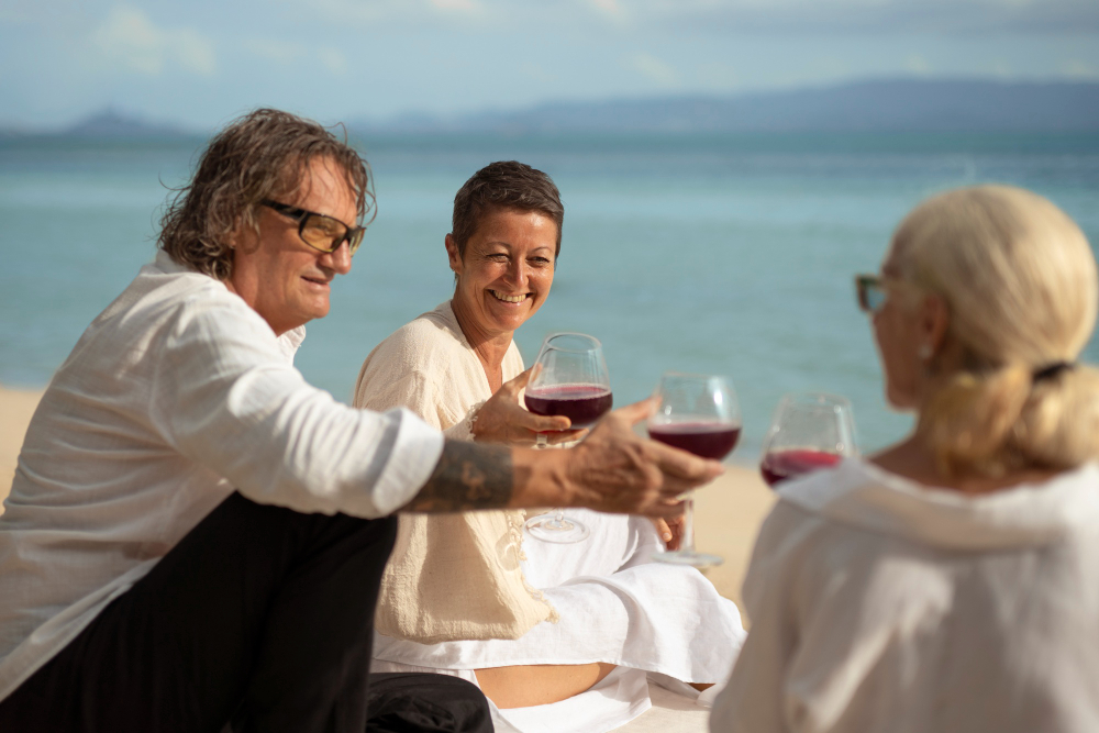 Older friends enjoying drinks by the beach